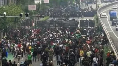 Ribuan massa memenuhi jalan di depan gedung DPR/MPR RI saat demo 25 Agustus, berhadapan dengan aparat kepolisian.