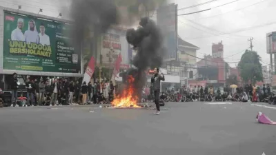 Mahasiswa menggelar aksi demonstrasi dengan membakar ban di jalan, mengecam kenaikan tunjangan DPR dan menuntut keadilan bagi rakyat.