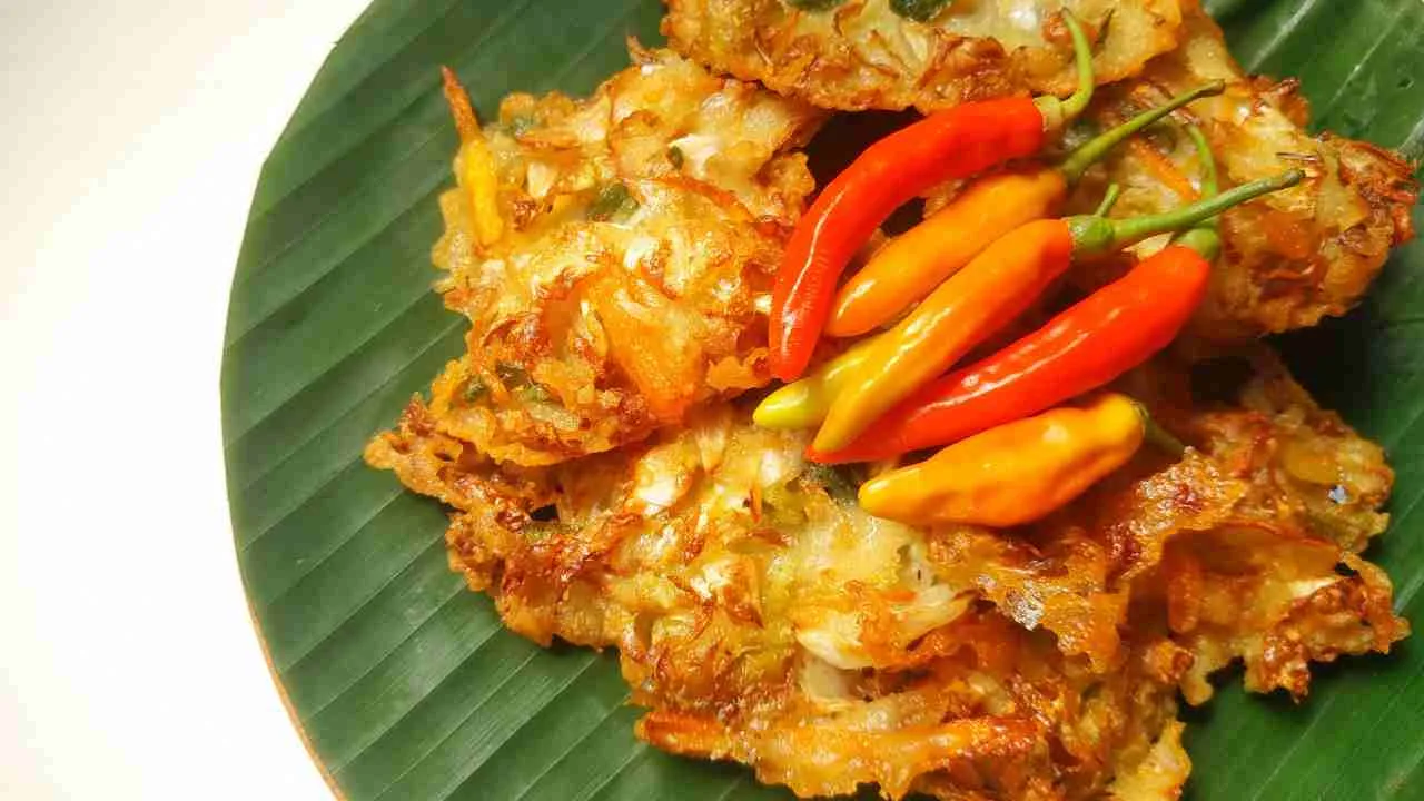 Bakwan sayur goreng renyah dengan cabai rawit disajikan di atas daun pisang