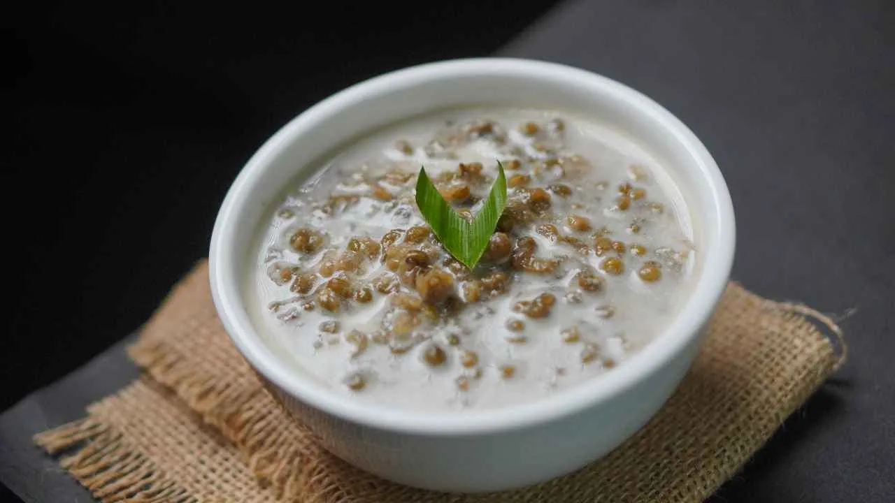 Bubur kacang hijau lembut dengan kuah santan gurih disajikan dalam mangkuk putih.