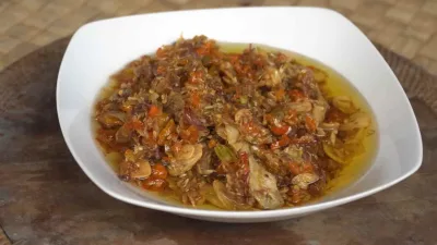Sambal serai khas Bali dengan bawang merah, cabai, dan bawang putih yang ditumis hingga harum, disajikan dalam piring putih.