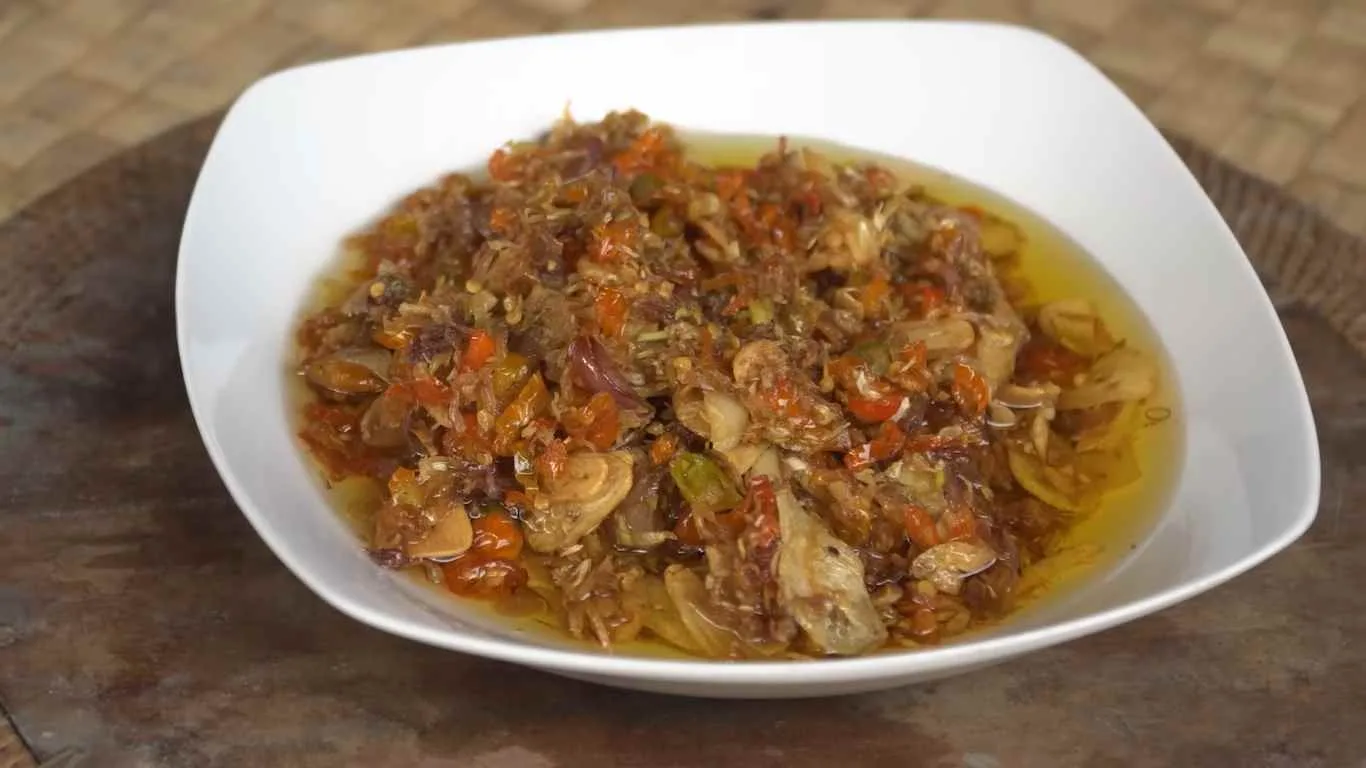 Sambal serai khas Bali dengan bawang merah, cabai, dan bawang putih yang ditumis hingga harum, disajikan dalam piring putih.