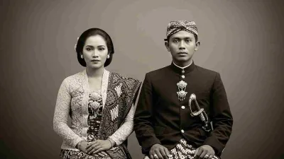 Foto hitam putih pasangan Jawa tempo dulu mengenakan kebaya dan beskap, bergaya formal dengan ekspresi serius khas potret tradisional.