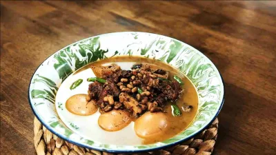 Semangkuk brongkos daging sapi khas Jogja dengan kacang tolo, telur rebus, dan kuah cokelat gurih