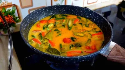 Oseng ikan pindang keranjang kuah santan dengan cabai hijau dan tomat segar dalam wajan.