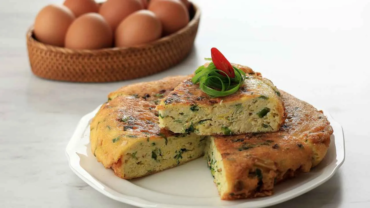 Telur dadar Padang tebal dan gurih dengan irisan daun bawang, disajikan di piring putih.