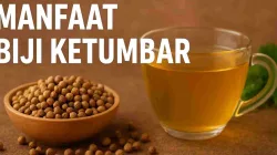 Segelas air rebusan biji ketumbar dan mangkuk kayu berisi biji ketumbar di atas meja cokelat.