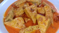 Sepiring gulai tempe tahu ala warteg dengan kuah santan kuning kemerahan yang gurih, disajikan dengan taburan bawang goreng di atasnya.