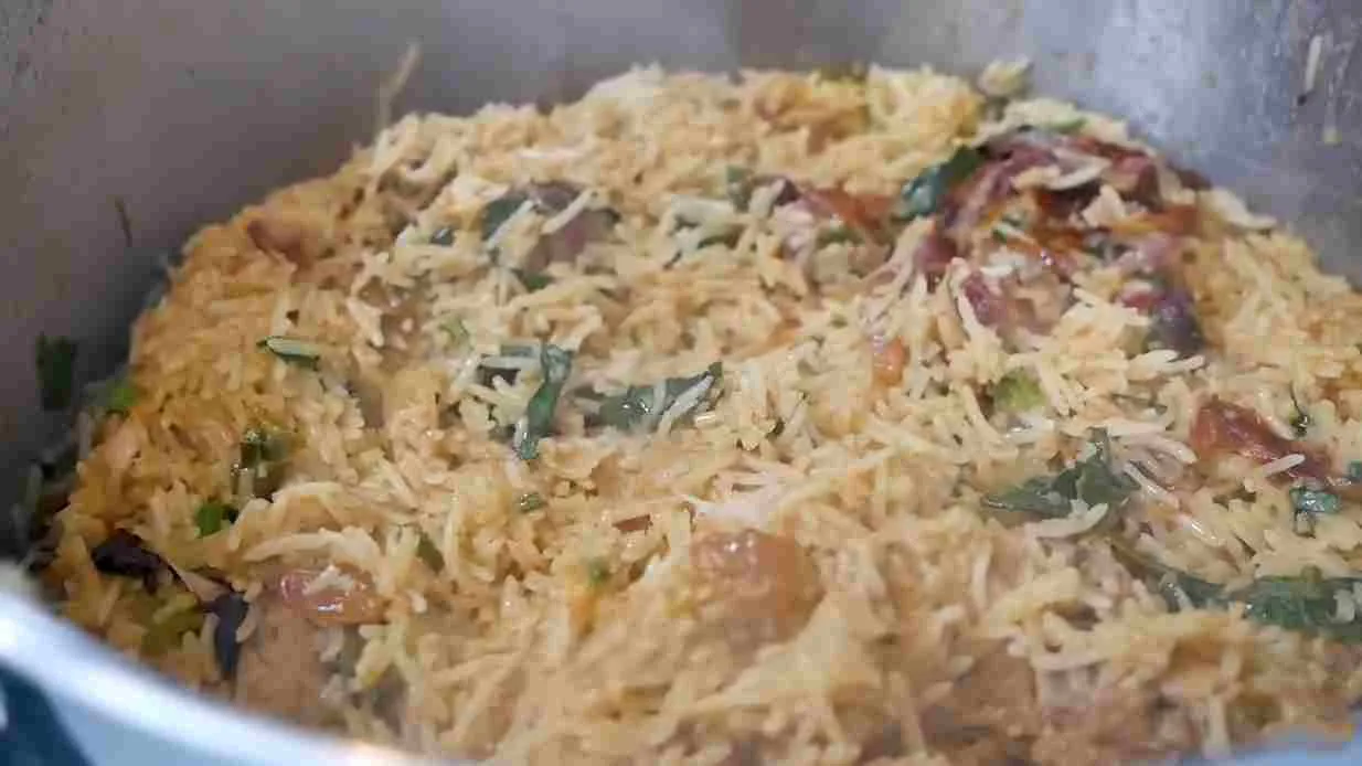 Nasi briyani ayam sederhana yang baru matang dengan aroma rempah yang menggugah selera di dalam panci.