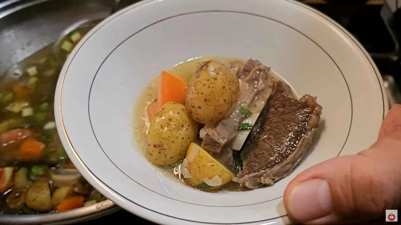 Semangkuk sop iga sapi dengan potongan daging iga empuk, kentang, dan wortel dalam kuah bening gurih.