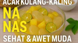 Acar kolang-kaling nanas segar dalam mangkuk kaca dengan potongan jeruk kalamansi dan nanas, menampilkan warna kuning cerah yang menggugah selera.