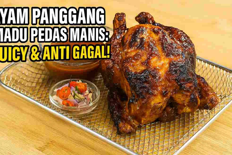 Ayam panggang madu pedas manis utuh dengan kulit karamel mengilap, disajikan di atas rak pemanggang bersama saus madu pedas dan sambal segar.