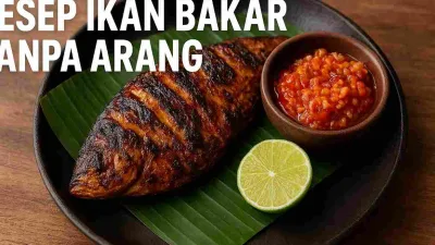 Ikan bakar tanpa arang disajikan di atas daun pisang dengan sambal kecap pedas dan irisan jeruk nipis di atas piring hitam.