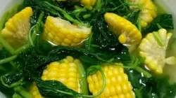 Semangkuk sayur bening bayam jagung manis dengan kuah jernih, berisi potongan jagung muda dan daun bayam segar.