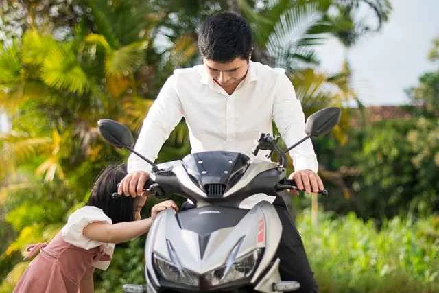 Ayah bersama anak kecil di dekat motor, menggambarkan kedekatan dan perhatian ayah terhadap tumbuh kembang anaknya.