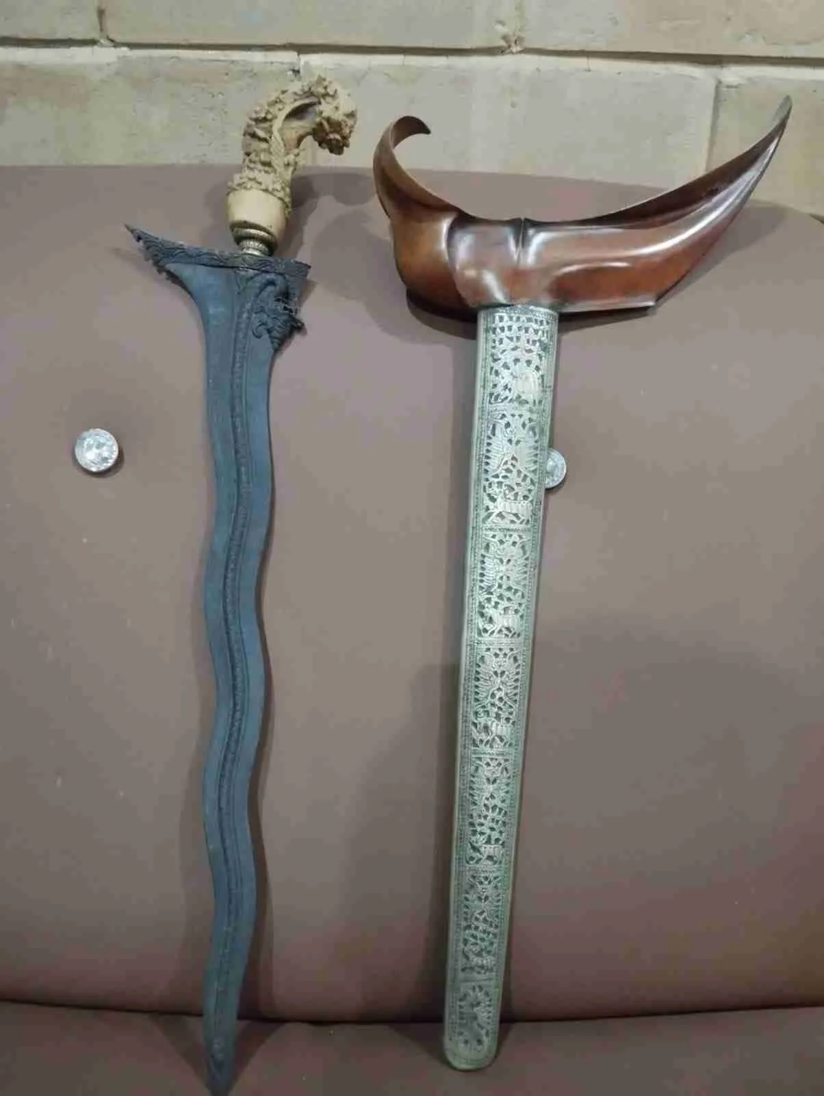 Sepasang keris Jawa dengan bilah berluk dan warangka ukiran motif tradisional, melambangkan pusaka dan simbol kekuasaan raja.